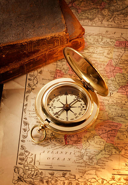 istock Gold Compass on Antique Map Old Worn Books in Background 171225133