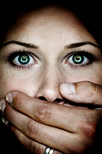 Abuse A woman with a big hand over her mouth looking scared.More from this model: green eyes photos stock pictures, royalty-free photos & images