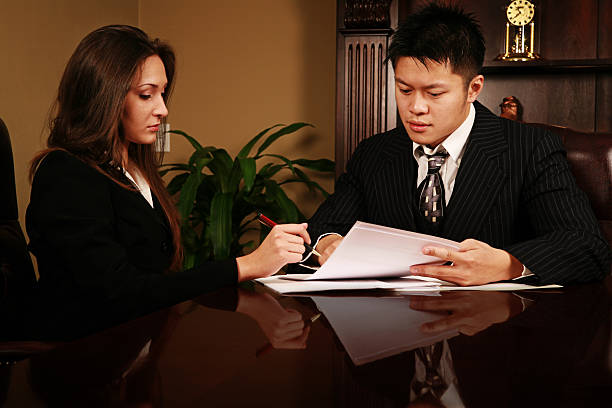 Signing Papers two young adults (twenty) in an office signing papers modelkt stock pictures, royalty-free photos & images