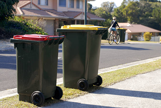 Two rubbish bins in Australia. Red lid is rubbish, yellow lid is recycling.