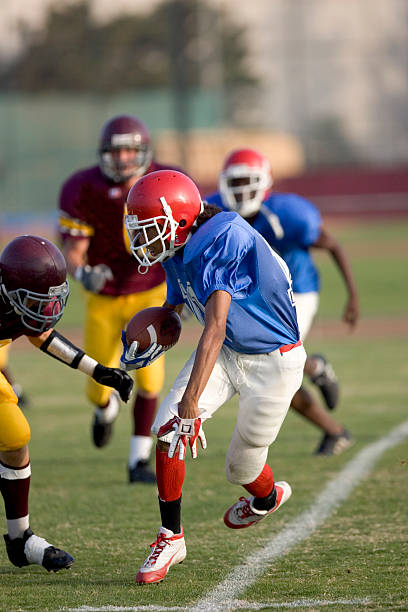 Evading the Tackle Running Back carrying the football. school sport high up tall stock pictures, royalty-free photos & images