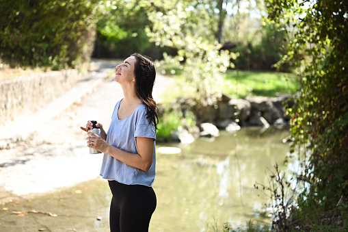 side view portrait of a woman breathing a fresh air after a workout outdoors in nature.