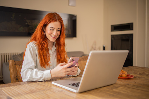 Happy young woman is enjoying working from home