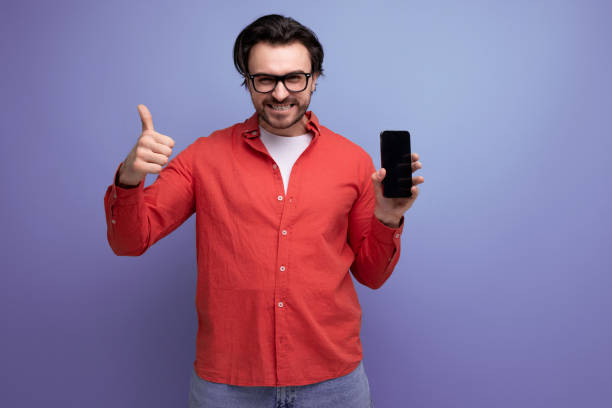 istock smart confident young brunette man in glasses advertises smartphone 1712314038