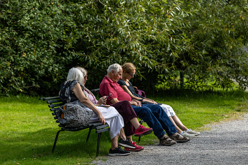 Three senior men sitting on the bench and talking