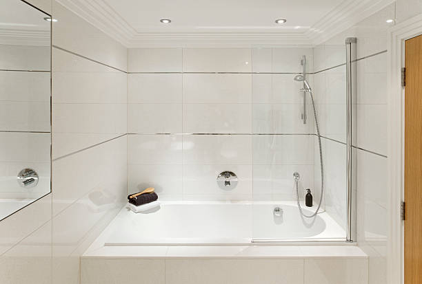 bath and shower "a white enamel bath with shower unit and glass shower screen in a guest's bathroom set in off-white tiles. An attractive cornice and stainless steel inserts add a touch of class to the room. Lightly dressed for the image with a liquid soap container, towels and back-brush. Looking for a Bathroom image Then please see my other Bathrooms and related inages by clicking on the Lightbox link below...A>AA>A" back brush stock pictures, royalty-free photos & images