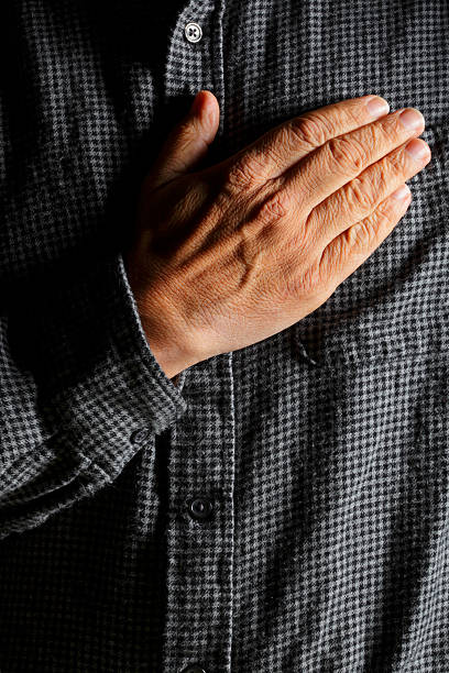 hombre hispano realizar su mano sobre el corazón - hand on heart fotografías e imágenes de stock