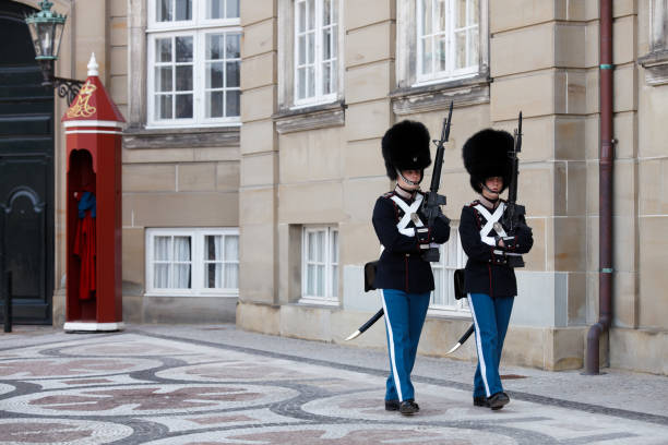 Copenhagen, Denmark - March 18, 2010:  The famous guard shift at Amalienborg, - the Roual Castle where the Queen of Denmark & her husband his royal Highness Prince Henri of Denmark resides. Everyday at noon the guards make a shift, after old tradition & ceremony. This is a huge tourist attraction in Copenhagen. 
