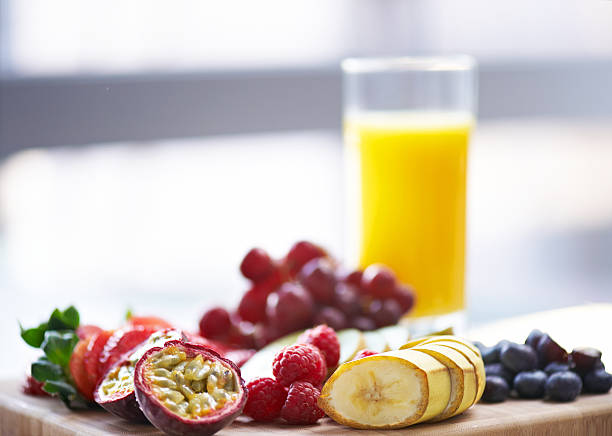 Healthy breakfast with orange juice and a bowl with strawberry, kiwi and pineapple.