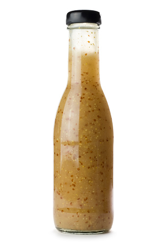 A bottle of salad dressing isolated on a white background.