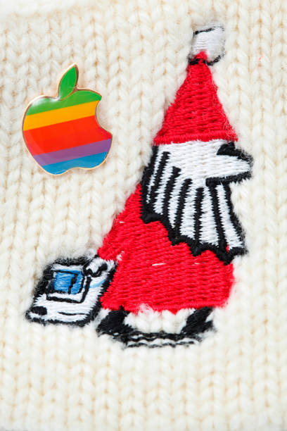 Classic Macintoch Santa Claus and apple pin "Cantley, Canada - May 8, 2012: This is an old 90's Macintoch Santa Claus embroidered on a wool headband and a classic Apple Mac pin badge with the rainbow color. This Apple pin with rainbow color is the first design of the original Apple Logo started in 1977 and ended in 1999." 1990 1999 photos stock pictures, royalty-free photos & images