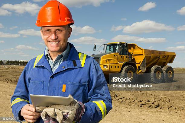 Trabajador De Construcción Y Pc Foto de stock y más banco de imágenes de Camión de descarga - Camión de descarga, Tableta digital, Agarrar