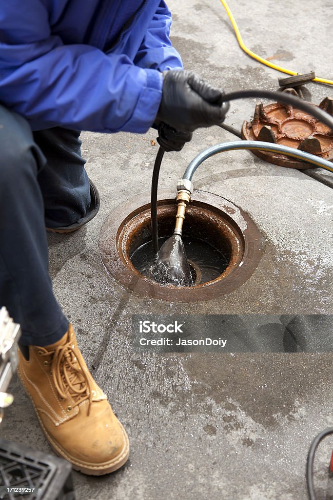 Commercial Plumbing: Camera Inspection Commercial plumbers check a pipe using a camera after hydro line jetting the pipe at a large restaurant. Sewer Stock Photo