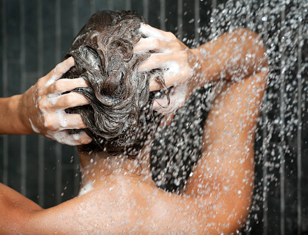 Woman washing her Hair with Shampoo under the Shower (XXXL) stock photo