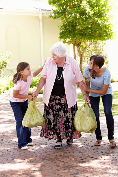 netos ajudar a avó para transporte de de compras - volunteer senior adult teenager occupation imagens e fotografias de stock