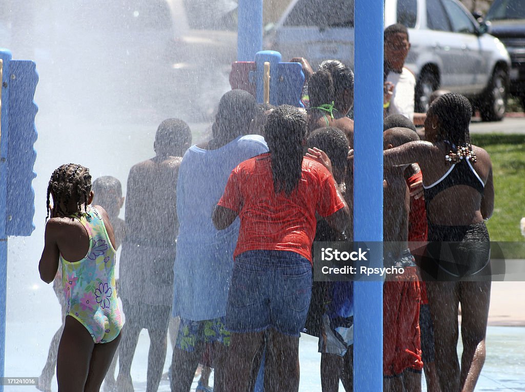 Summer Mist City kids cool off from the hot summer sun in a water park. City Stock Photo