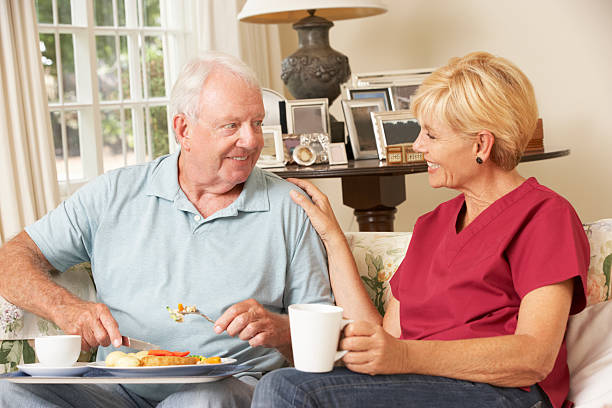 船の助手のお食事をお出しする老人男性と自宅でケア - senior adult nursing home eating home interior ストックフォトと画像