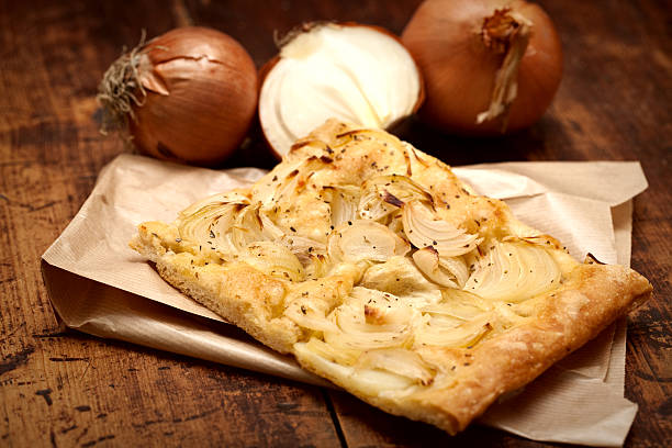 close-up of pizza with onion on wooden table