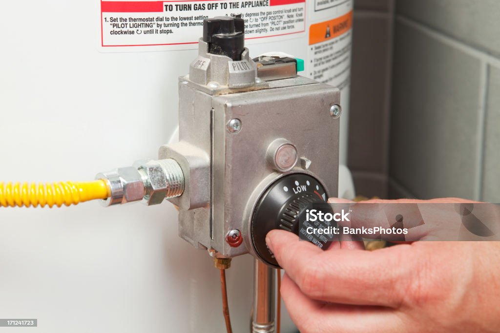 Mão, fechar o termostato do aquecedor de água - Foto de stock de Caldeira - Equipamento industrial royalty-free