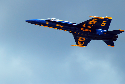 Wantagh, NY, USA May 23 A blue F14 twin engine military aircraft streaks across the sky over Wantagh, New York
