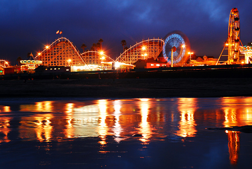 Santa Cruz, CA, USA August 12 The rides of the Boardwalk in Santa Cruz, California are illuminated at night and the lights are reflected in the water below