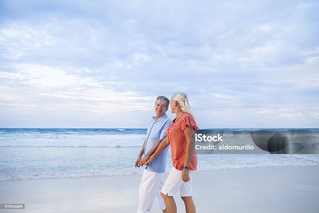 Sênior casal aproveita uma caminhada na praia - Foto de stock de Praia royalty-free