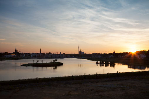 On the area of a former steel cooking plant  there was installed an artificial lake, lake Phoenix, symbol of the structural change of a former coal mining and steel cooking region, skyline of Dortmund with Florian tower