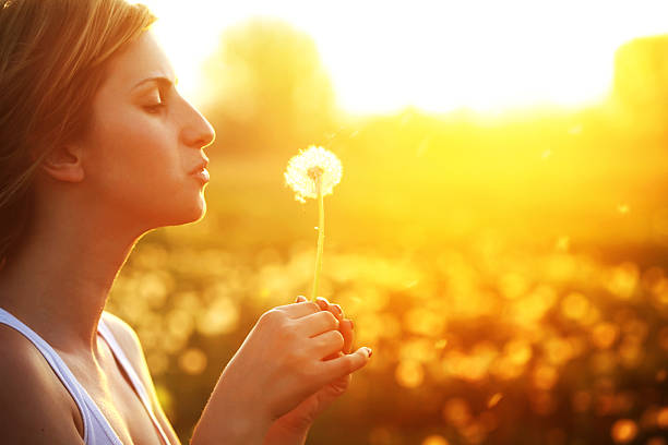 istock Beautiful young woman blowing a dandelion 171245784