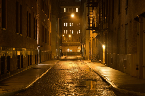 A lonely cobblestone street on a wet rainy night in New York City. 