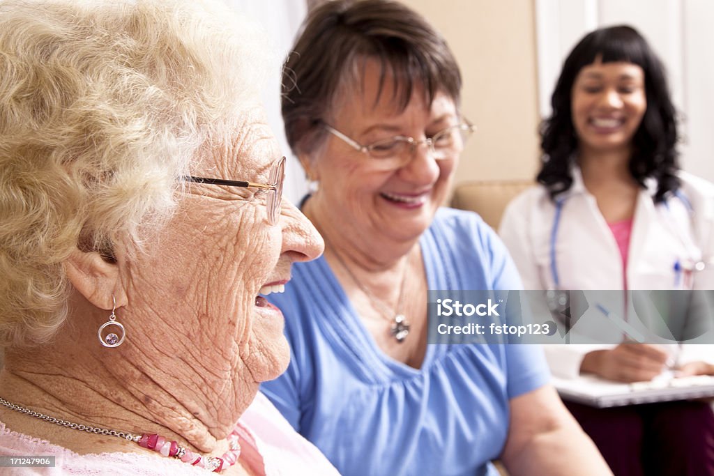 Senior mujer sonriente con hija y con el médico - Foto de stock de 30-39 años libre de derechos