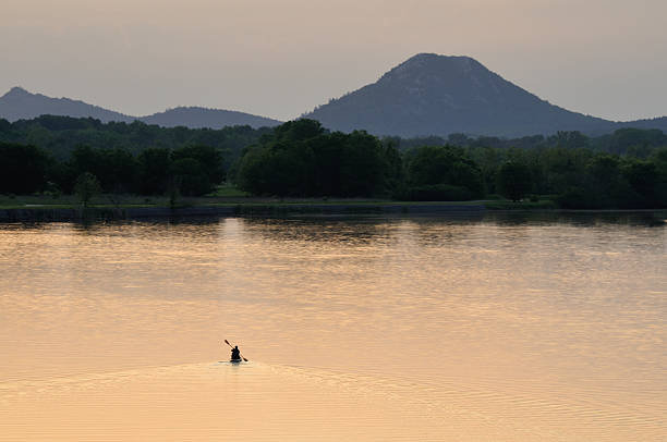 lone persona in canoa sul lago - pinnacle foto e immagini stock