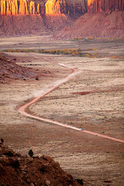 istock Car speeding down dusty desert road in Utah at sunset 171249509