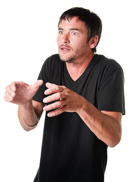 A handsome young man wearing a blank black t-shirt is shocked.See related: