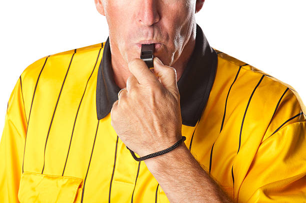 Soccer Referee Blowing Whistle Soccer referee in yellow jersey  blowing whistle foul stock pictures, royalty-free photos & images