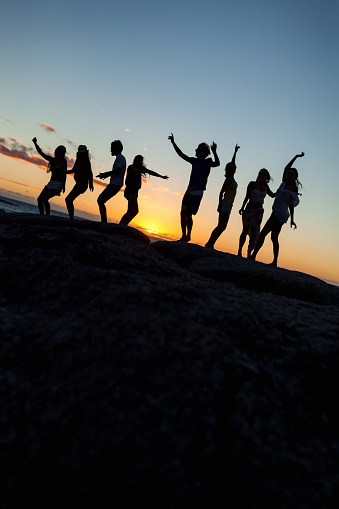 Young fun party people dancing on a rock at the seaside. Pls checkout our lightboxes for further images 