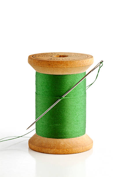 istock Sewing needle and wood spool of thread. On White. 171251451