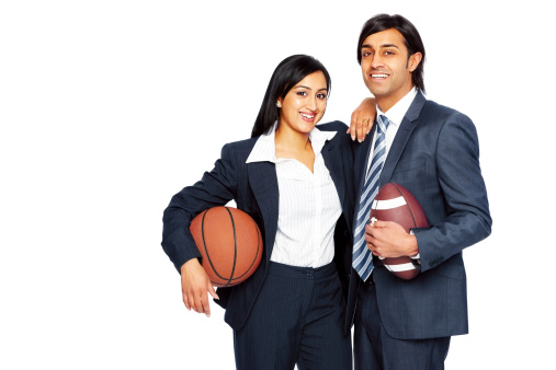 Successful young business couple holding basketball and American football isolated on white background