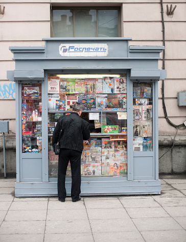 Strasbourg, France - Dec 4, 2020: Defocused view through multiple newspapers at press kiosk - German press