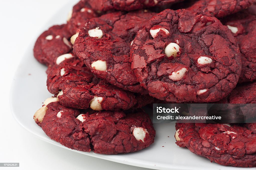Plate of Red Velvet Cookies Red velvet cookies with white chocolate chips on a white plate sitting on a white table. Red Velvet Flavor Stock Photo