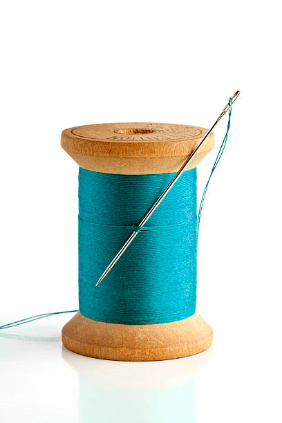 istock Sewing needle and wood spool of thread. On White. 171252620