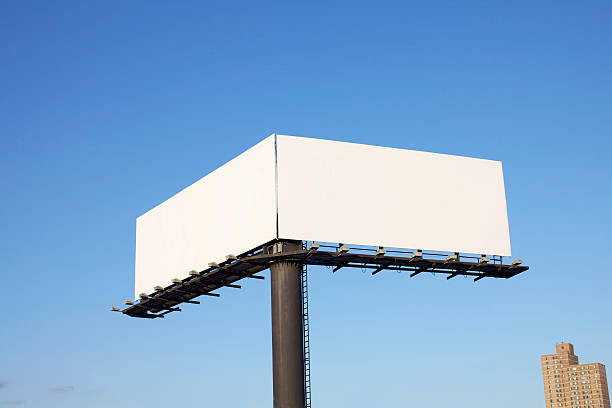 Double Billboard Extra Large Double Billboard over a Blue Sky with Sky Scraper. symmetry stock pictures, royalty-free photos & images