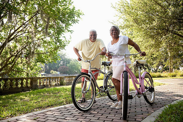 couple afro-américain senior équitation vélos - mature couple action senior couple senior adult photos et images de collection