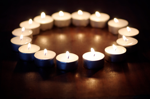 Candles alight On Polished wood surface.
