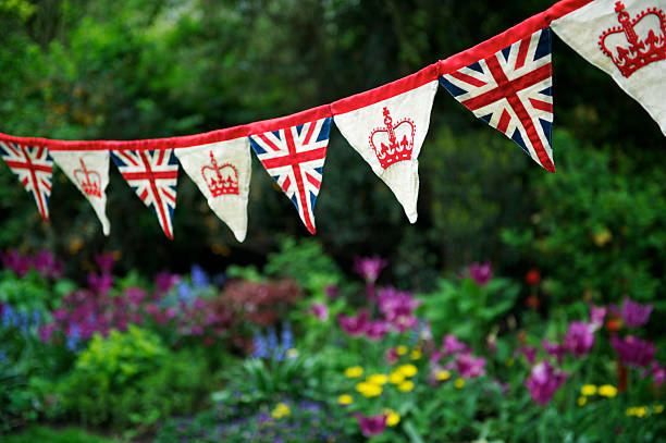 union jack bandeira britânica fazendo bandeirinha pairam no jardim inglês - british flag imagens e fotografias de stock