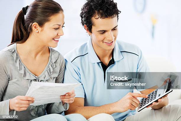 Joven Alegre Pareja Haciendo Sus Impuestos Foto de stock y más banco de imágenes de Parejas - Parejas, Ahorros, Calculadora