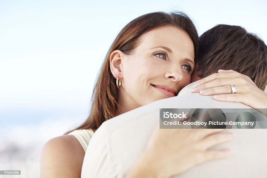 Contentment - Love &amp; Life A beautiful mature woman looking thankful as she embraces her husband outdoors Adult Stock Photo