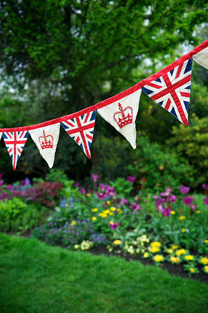 union jack krone feierliche bunting englischen garten royal – dekoration - jubilee bunting british flag flower bed stock-fotos und bilder