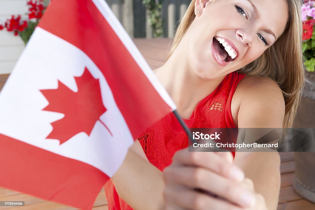 Young female celebrating Canada's Day Female holding a Canadian flag outdoors Canada Day Stock Photo