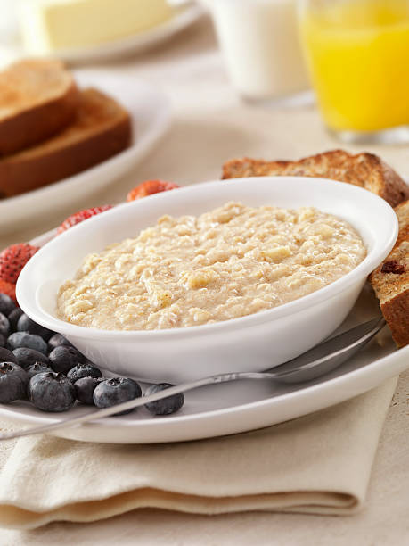 Hot Oatmeal "Hot Oatmeal with Fresh Fruit, Whole Grain Toast, Milk and Orange Juice- Photographed on Hasselblad H3D2-39mb Camera" Porridge with Milk stock pictures, royalty-free photos & images