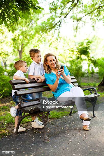 Photo libre de droit de Mère Et Enfants À Laide Dun Téléphone Mobile Dans Le Parc banque d'images et plus d'images libres de droit de Famille